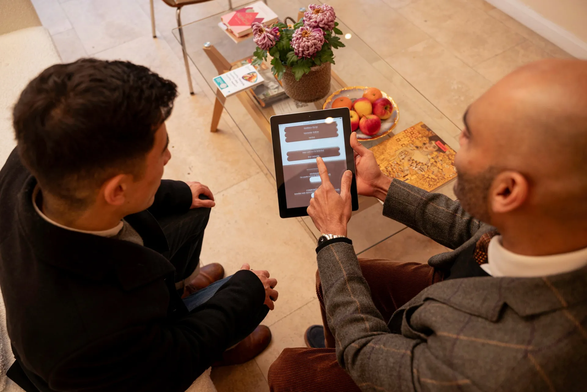 Masseter face slimming results: clinician showing a patient information on a tablet in the clinic lounge