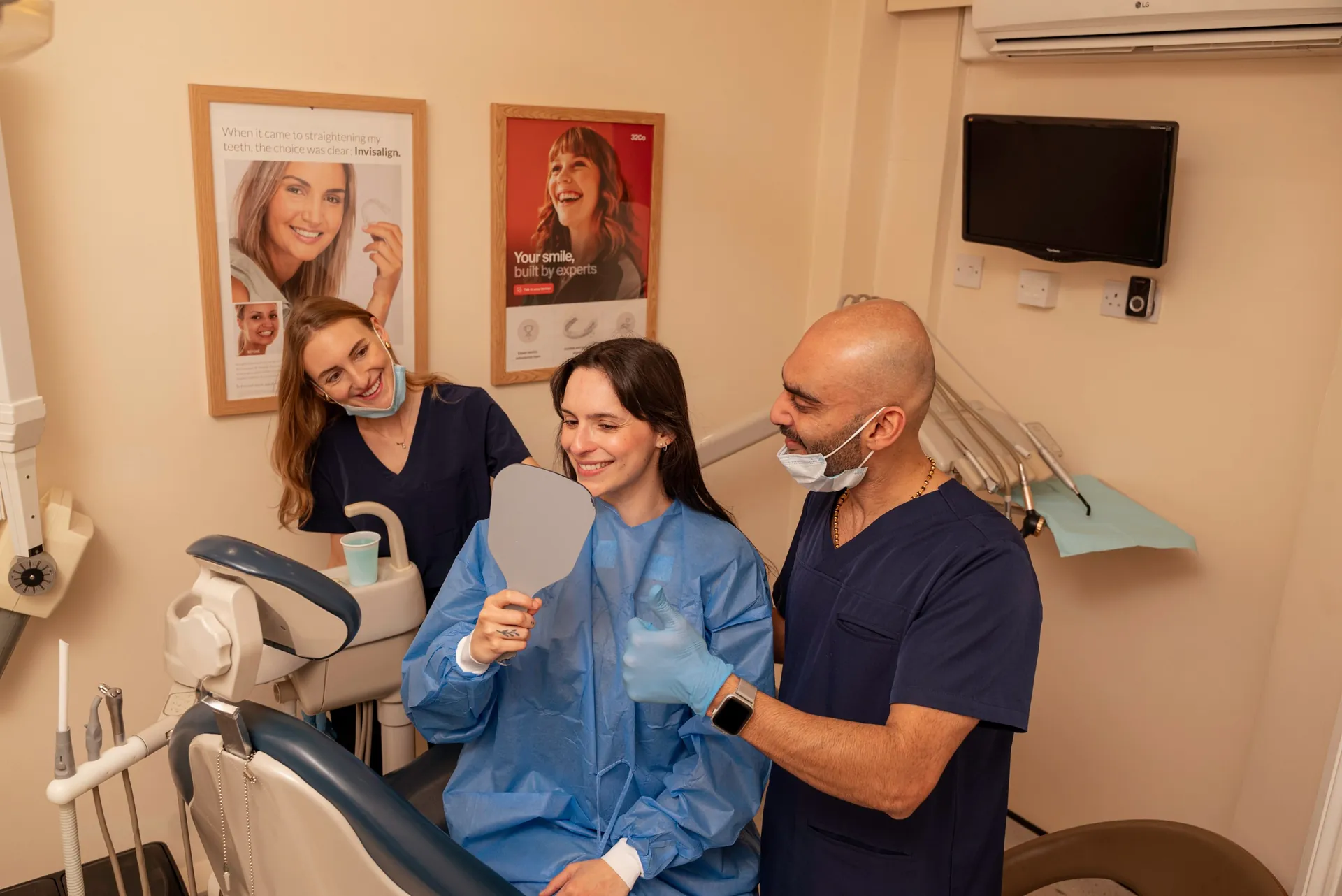 Profhilo in Islington, London: patient holding a mirror after treatment, with two clinicians beside the chair
