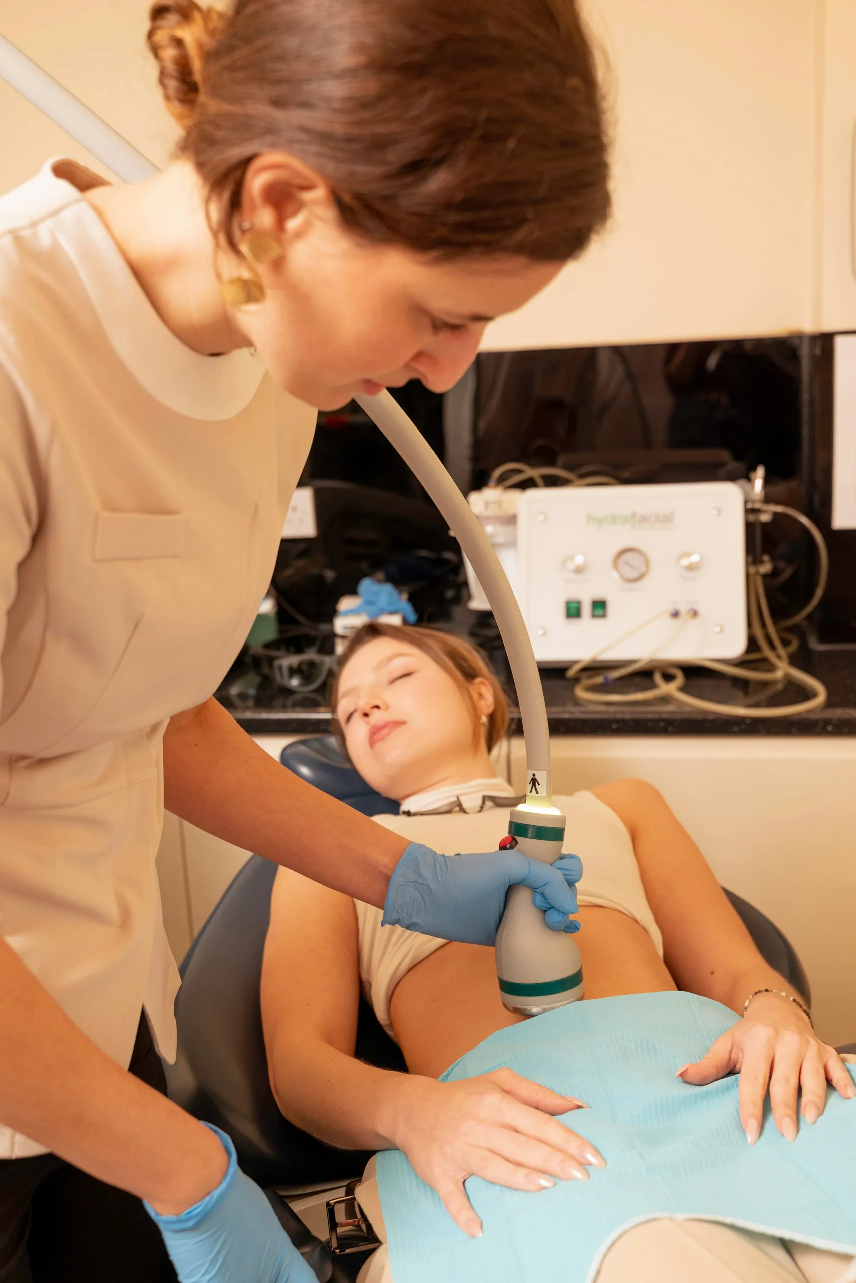 Coolsculpting alternative in Islington: therapist carrying out an Onda body treatment on a reclining patient's abdomen