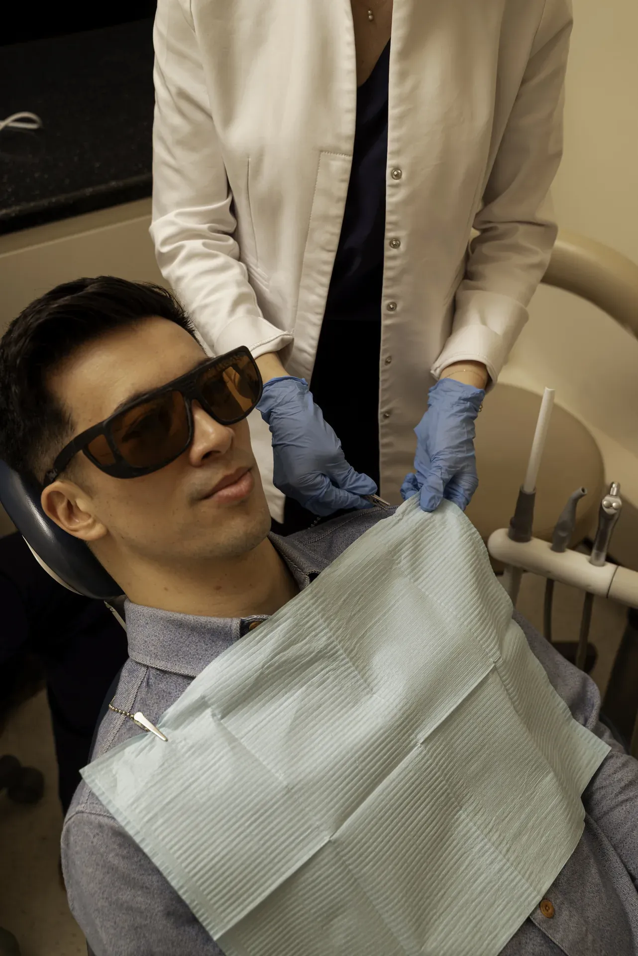 Tooth replacement treatment in Islington: patient in protective glasses in the dental chair with a clinician beside him