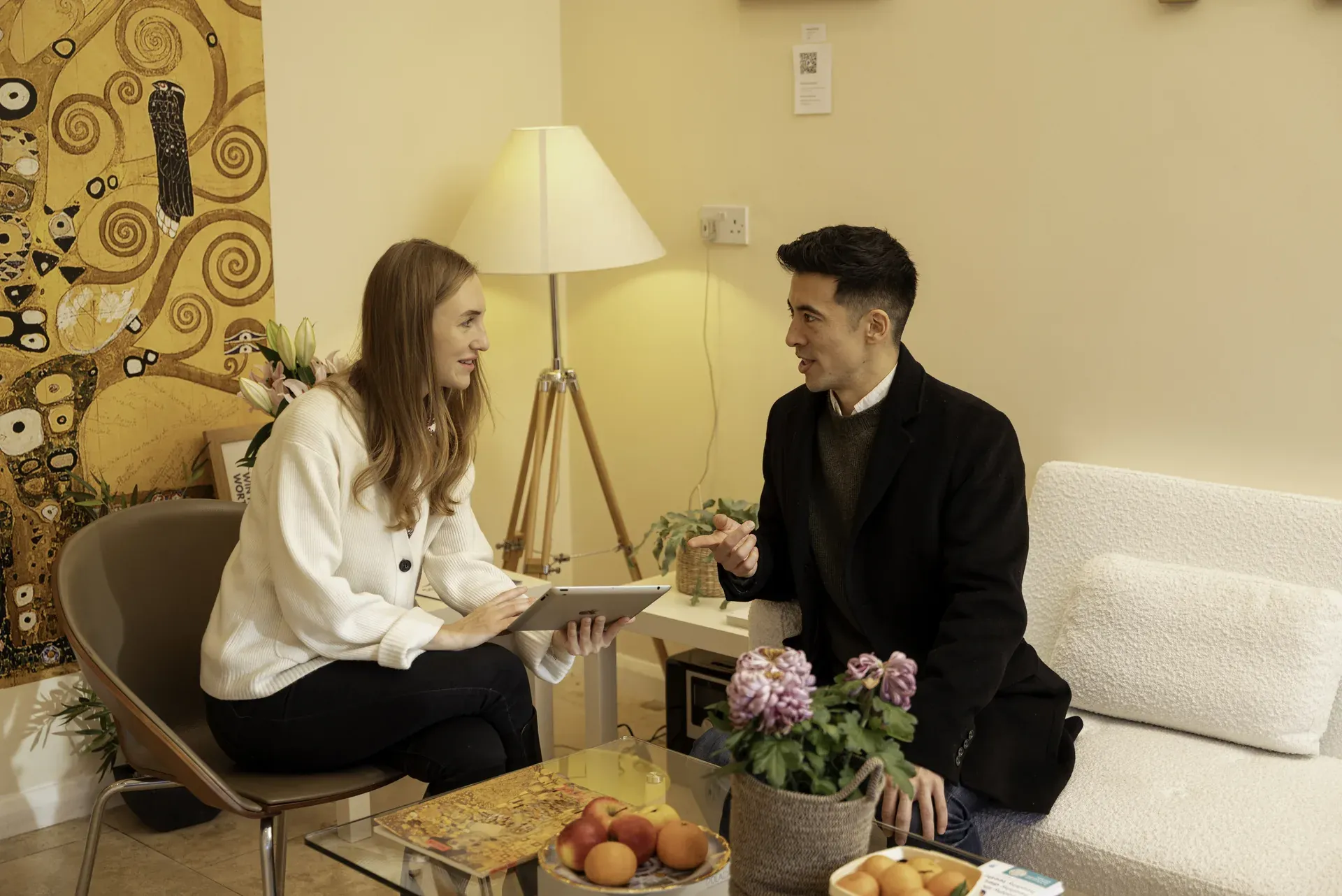 Practitioner and client talking over a tablet in the clinic lounge — executive coach