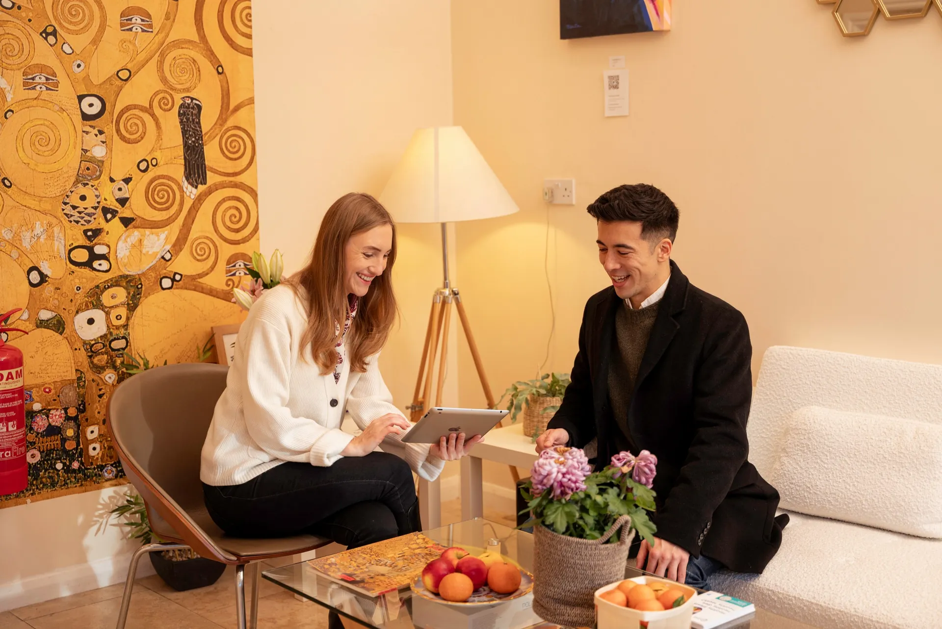 Practitioner and client talking over a tablet in the clinic lounge — veneers