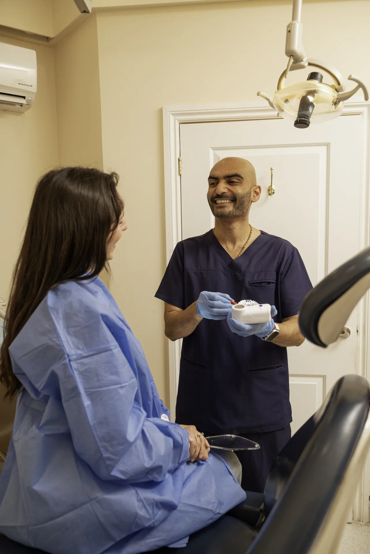 Volite in Islington, London: dentist talking with a patient in a treatment gown in the surgery