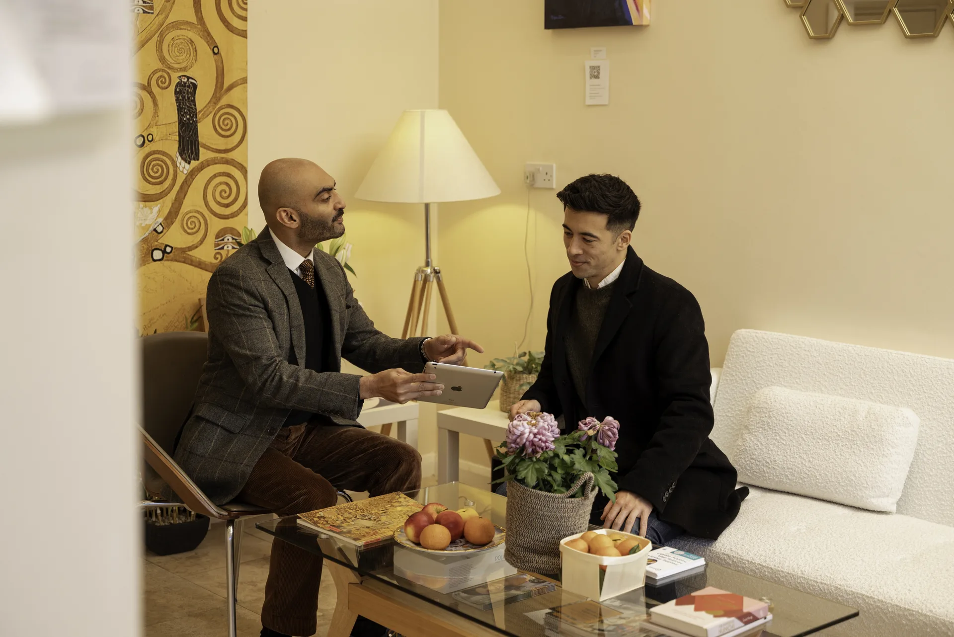 Teeth grinding and bruxism treatment in Islington: clinician and patient in consultation over a tablet in the clinic lounge