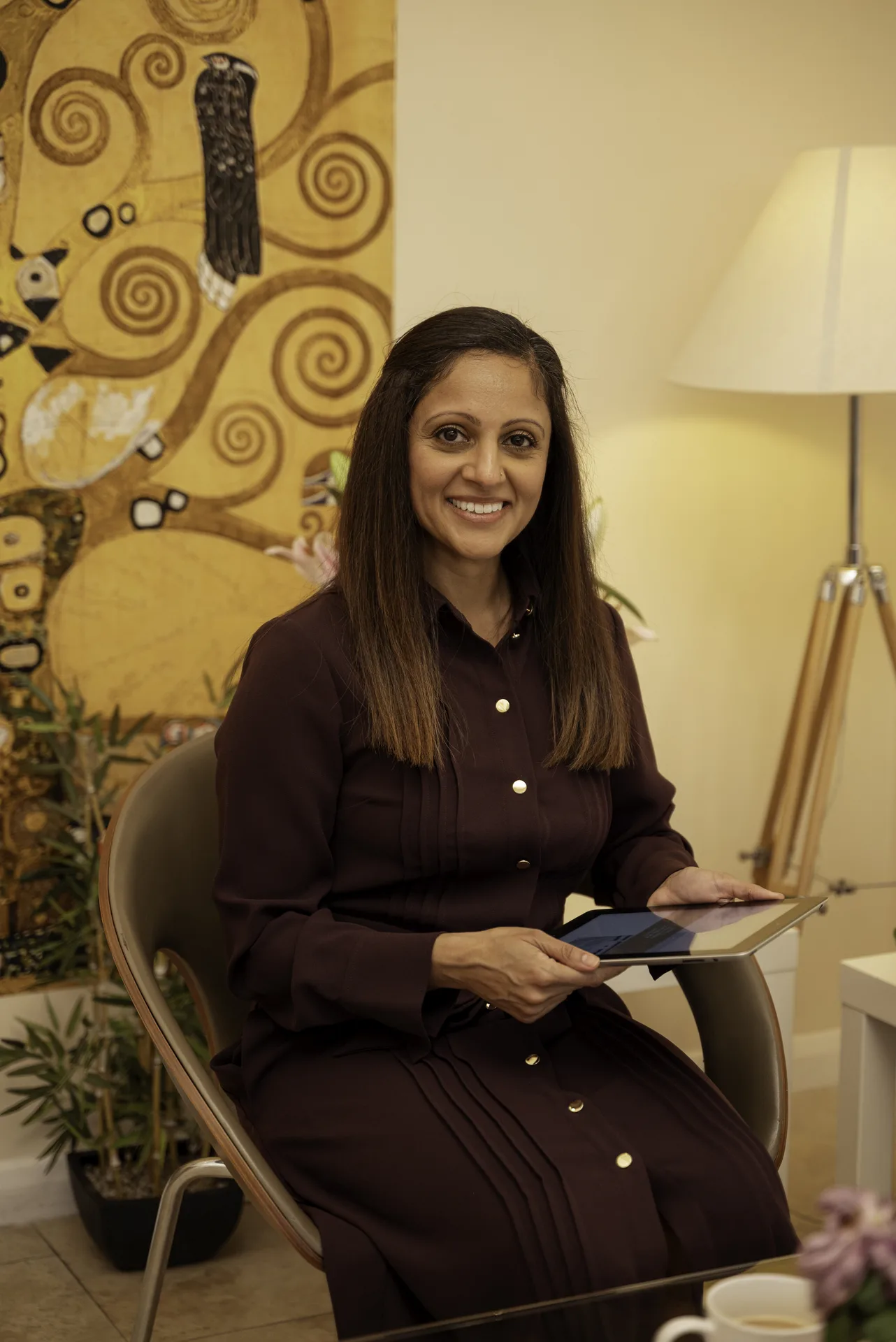 Mindfulness course in Islington, London: wellness practitioner seated in the clinic lounge holding a tablet