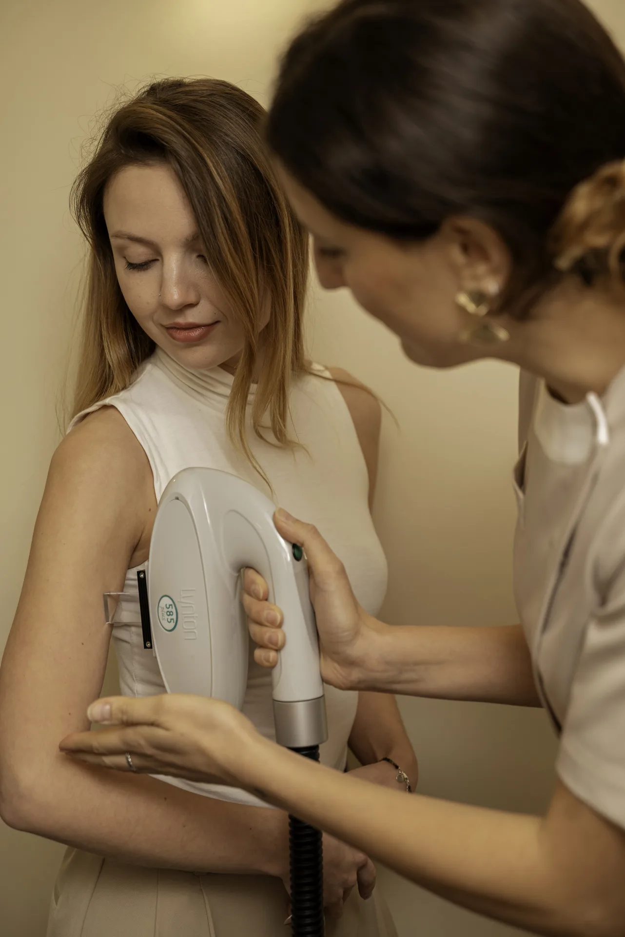 PicoSure alternative in Islington, London: therapist using a laser handpiece on a patient's upper arm