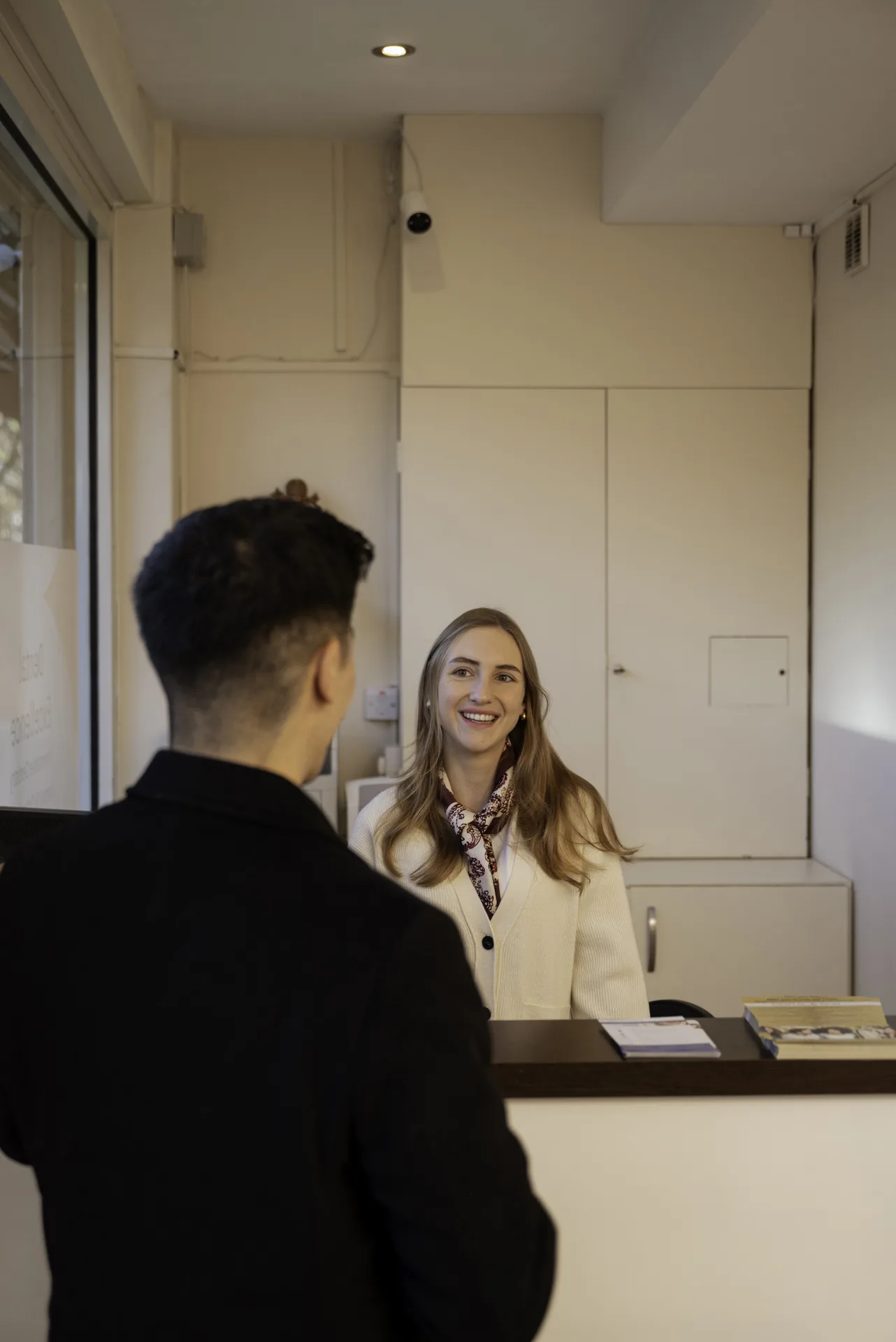 Dentist for Holloway: receptionist greeting a patient at the front desk