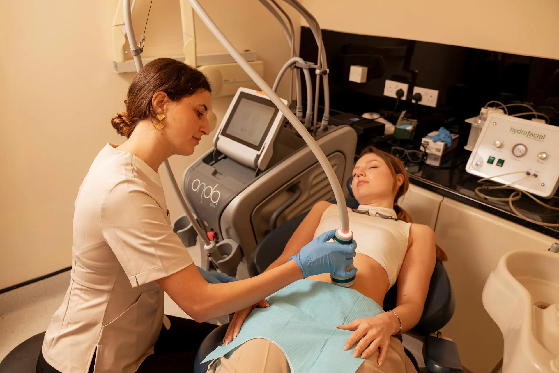 Therapist carrying out an Onda body treatment on a reclining patient — non-surgical fat removal