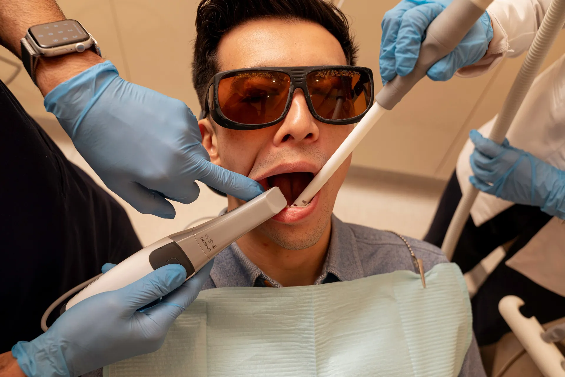 Patient in protective glasses having an intraoral scan with the dental team — Invisalign dual arch cost