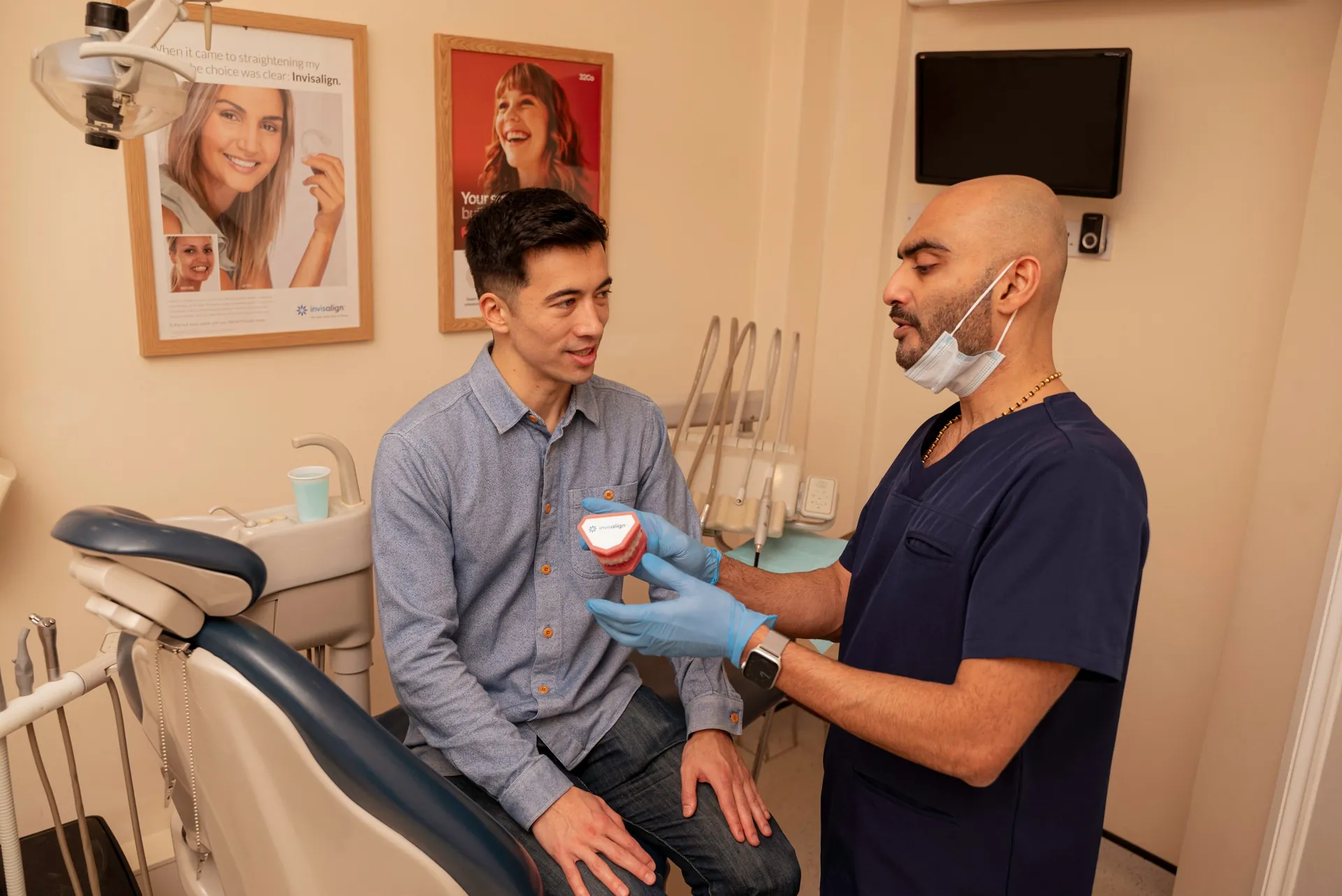 Dentist showing a seated patient a dental model — long-term functional outcomes with Invisalign