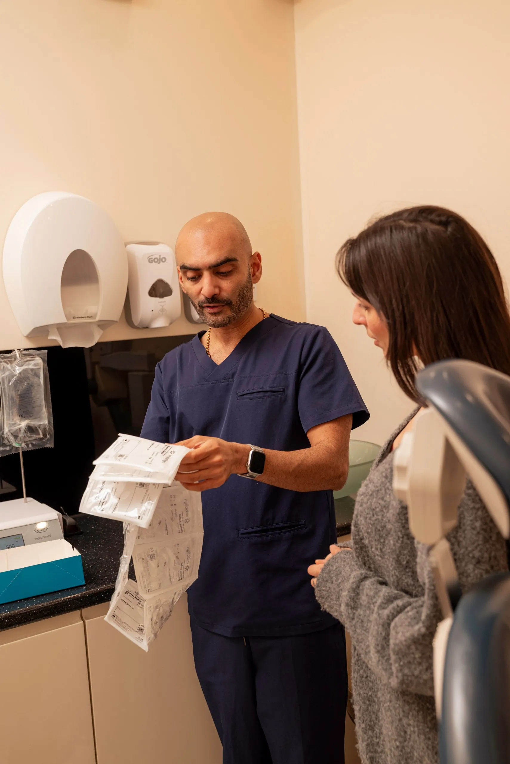 Kissing with Invisalign: dentist reviewing aligner paperwork with a patient in the surgery