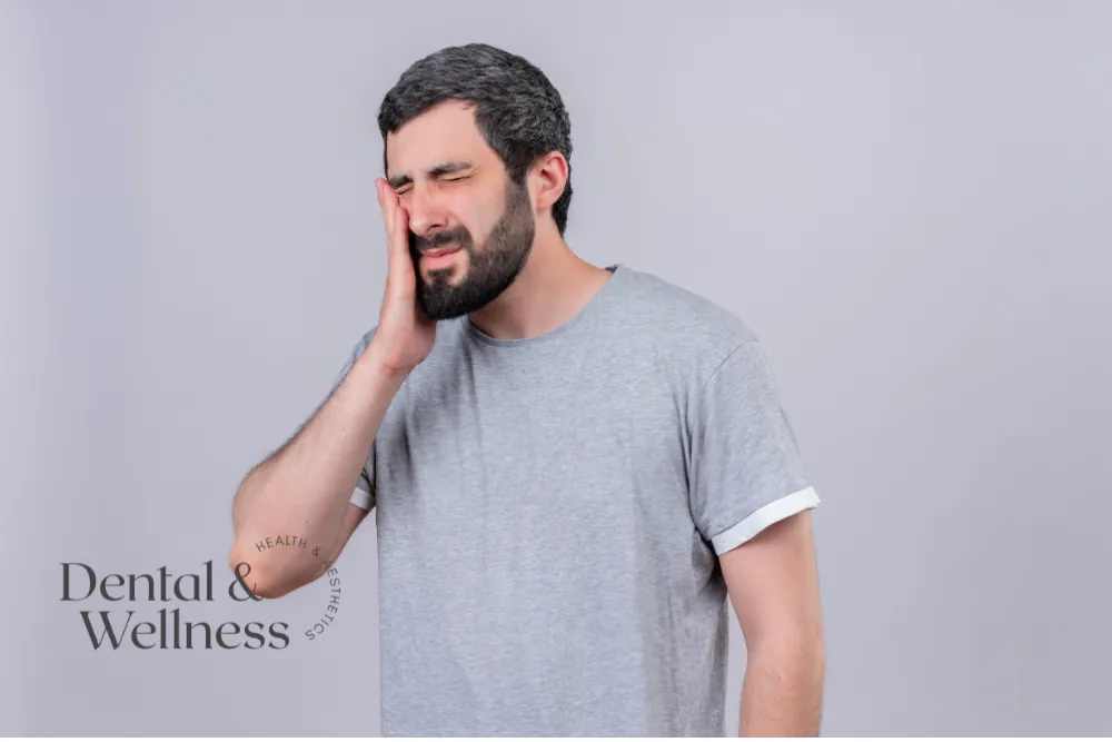 Man wincing and holding his cheek with toothache — tooth abscess infection