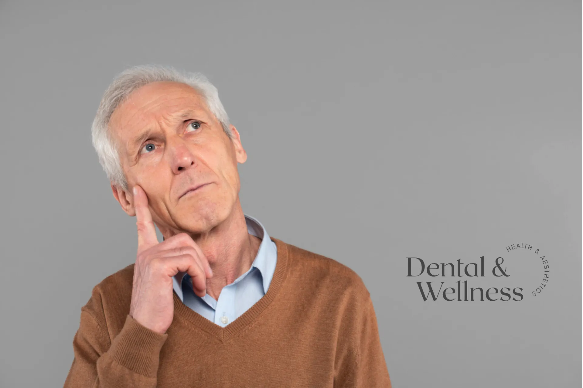 Older man looking thoughtful with a finger to his cheek