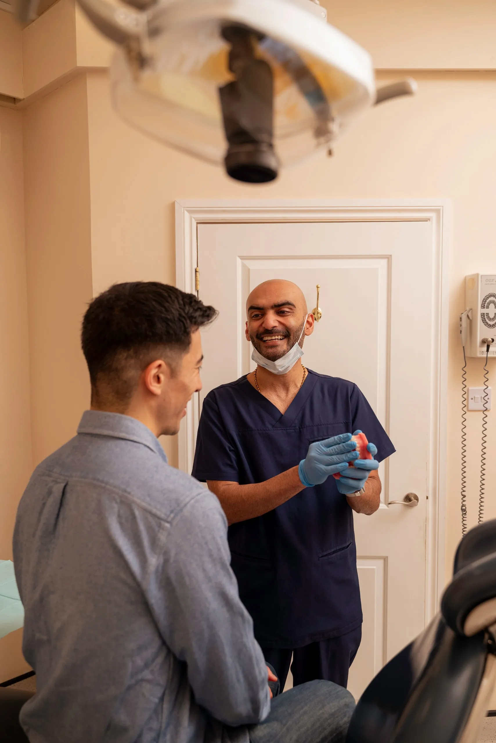 Edge bonding vs full coverage bonding: dentist greeting a patient at the door of the treatment room