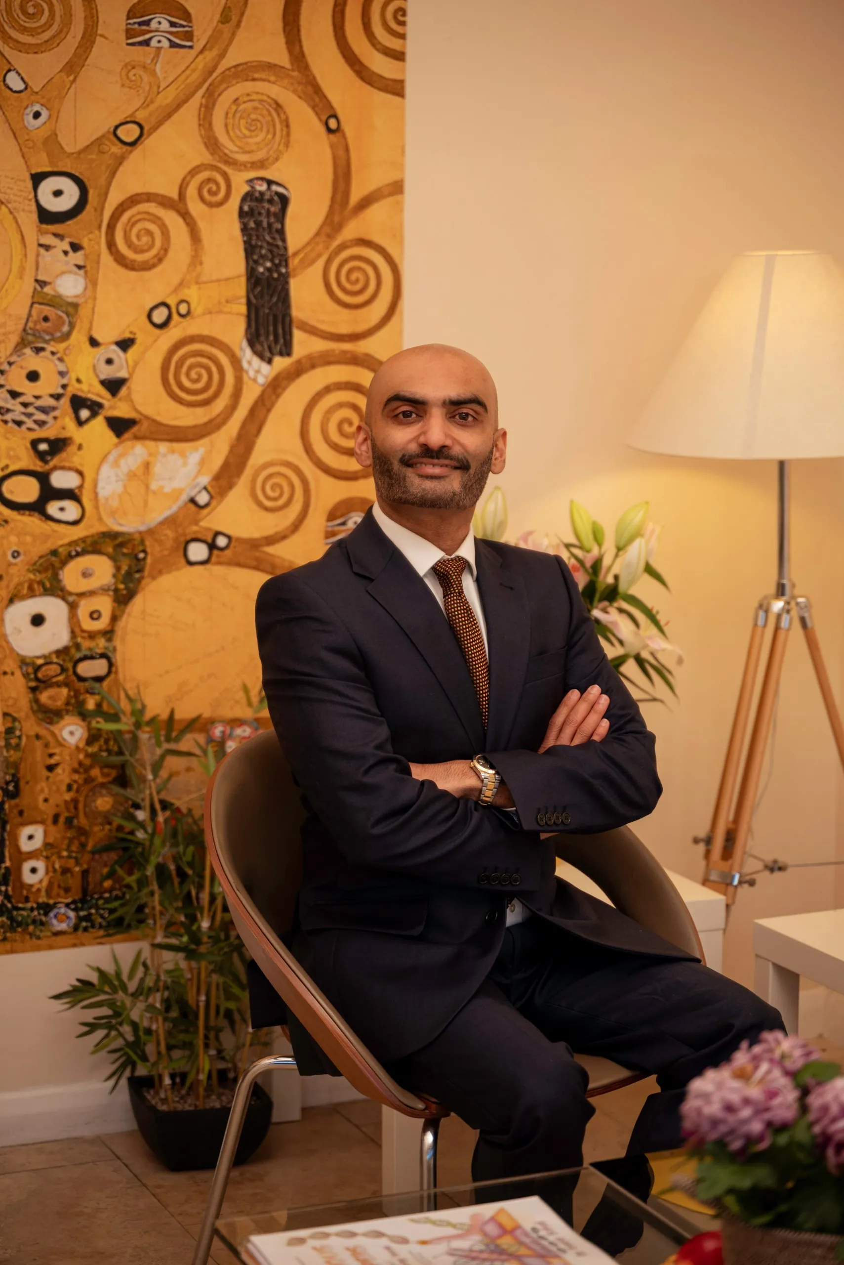 Dentist in a suit seated in the clinic lounge