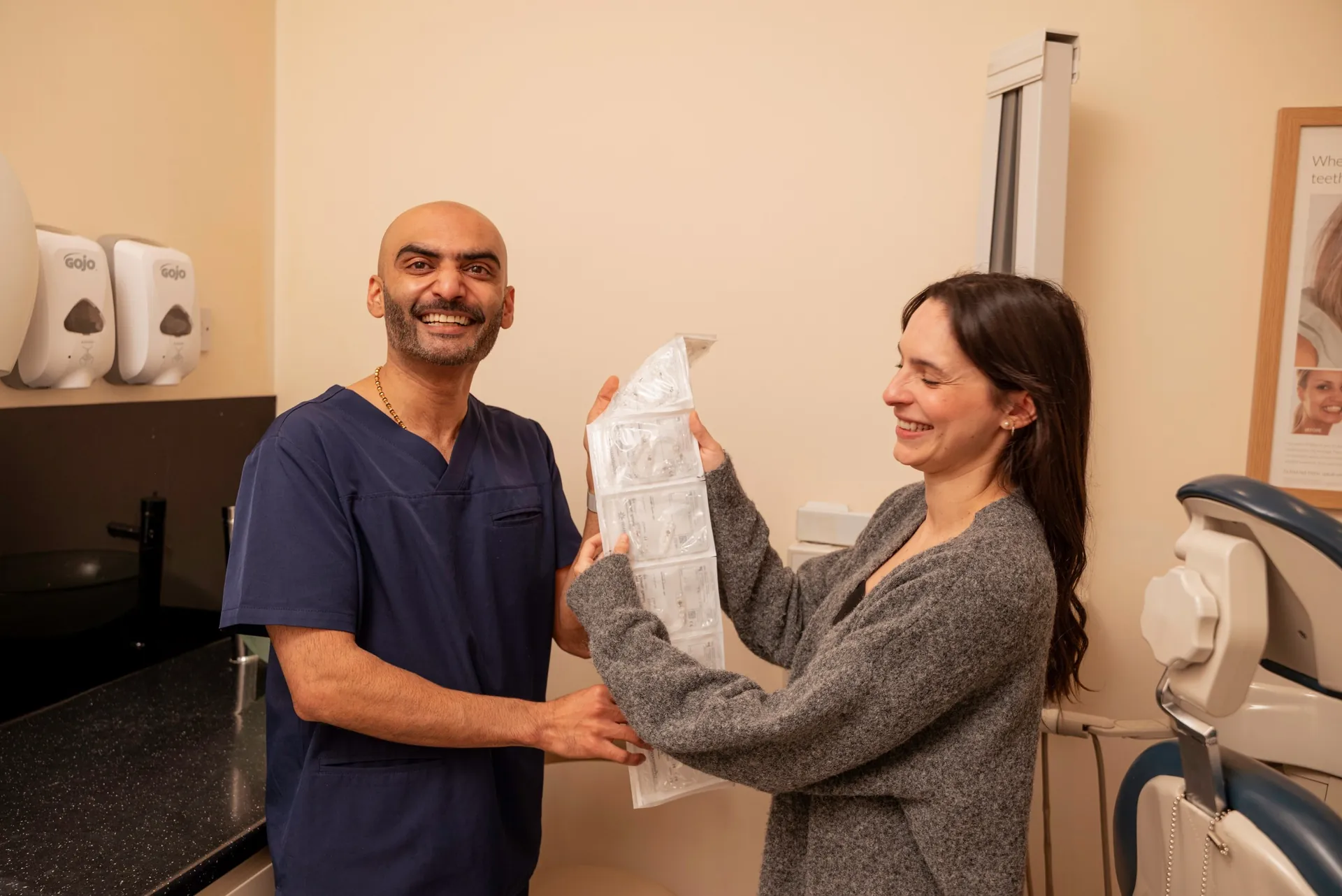 Dentist and patient holding up her aligner treatment pack together