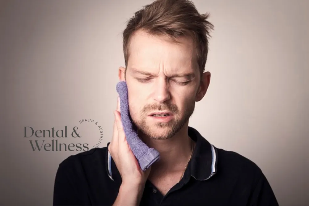 Man holding a cold compress to his cheek with toothache — emergency dentist