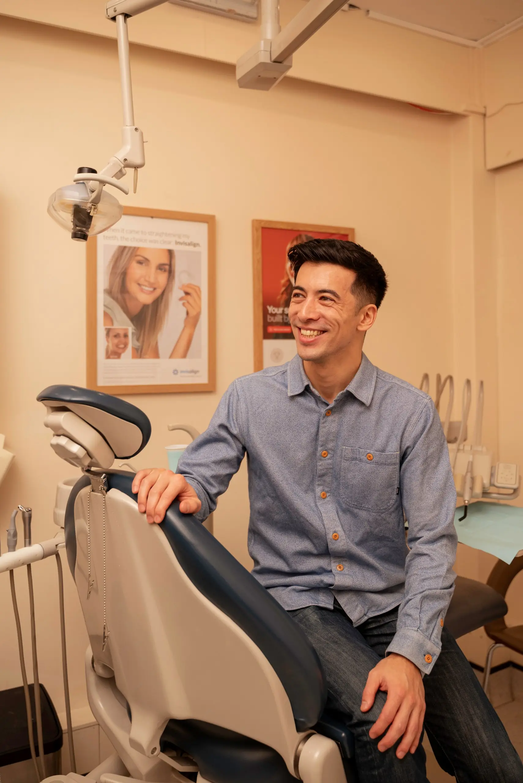Composite bonding staining: smiling patient seated on the edge of the dental chair