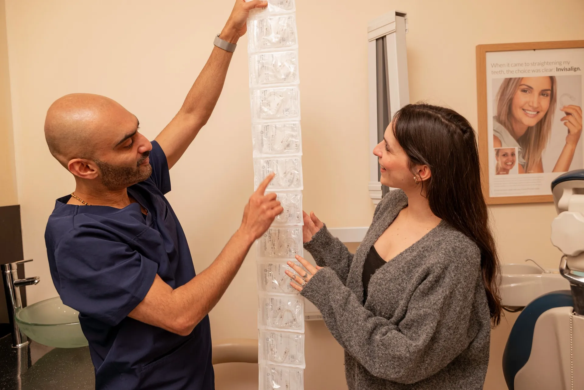 Dentist unrolling a patient's full series of clear aligners in the surgery — cleaning Invisalign