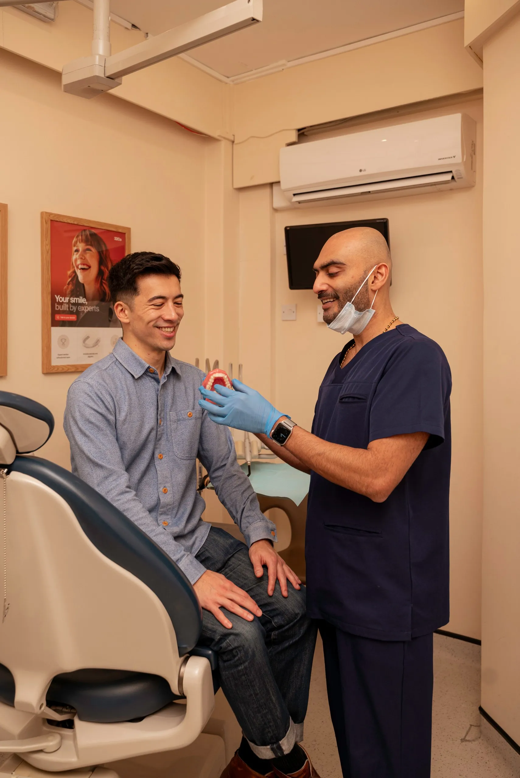 Invisalign non-extraction method: dentist examining a seated patient in the treatment room