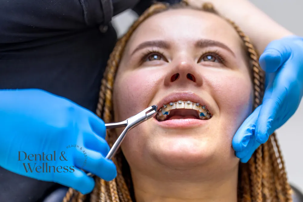 Orthodontist adjusting a smiling patient's fixed braces