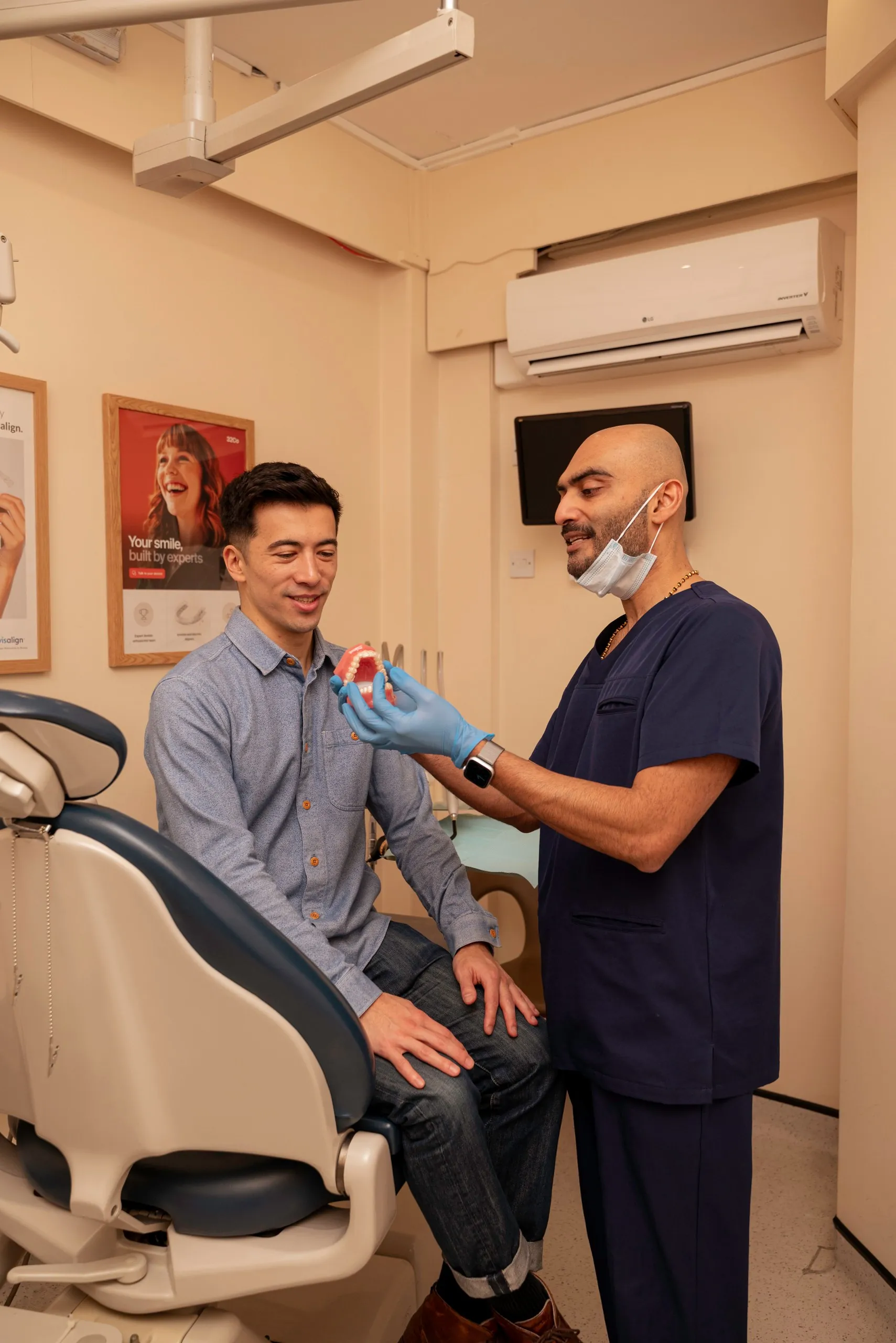 Invisalign for overbite treatment: dentist examining a patient seated on the edge of the dental chair