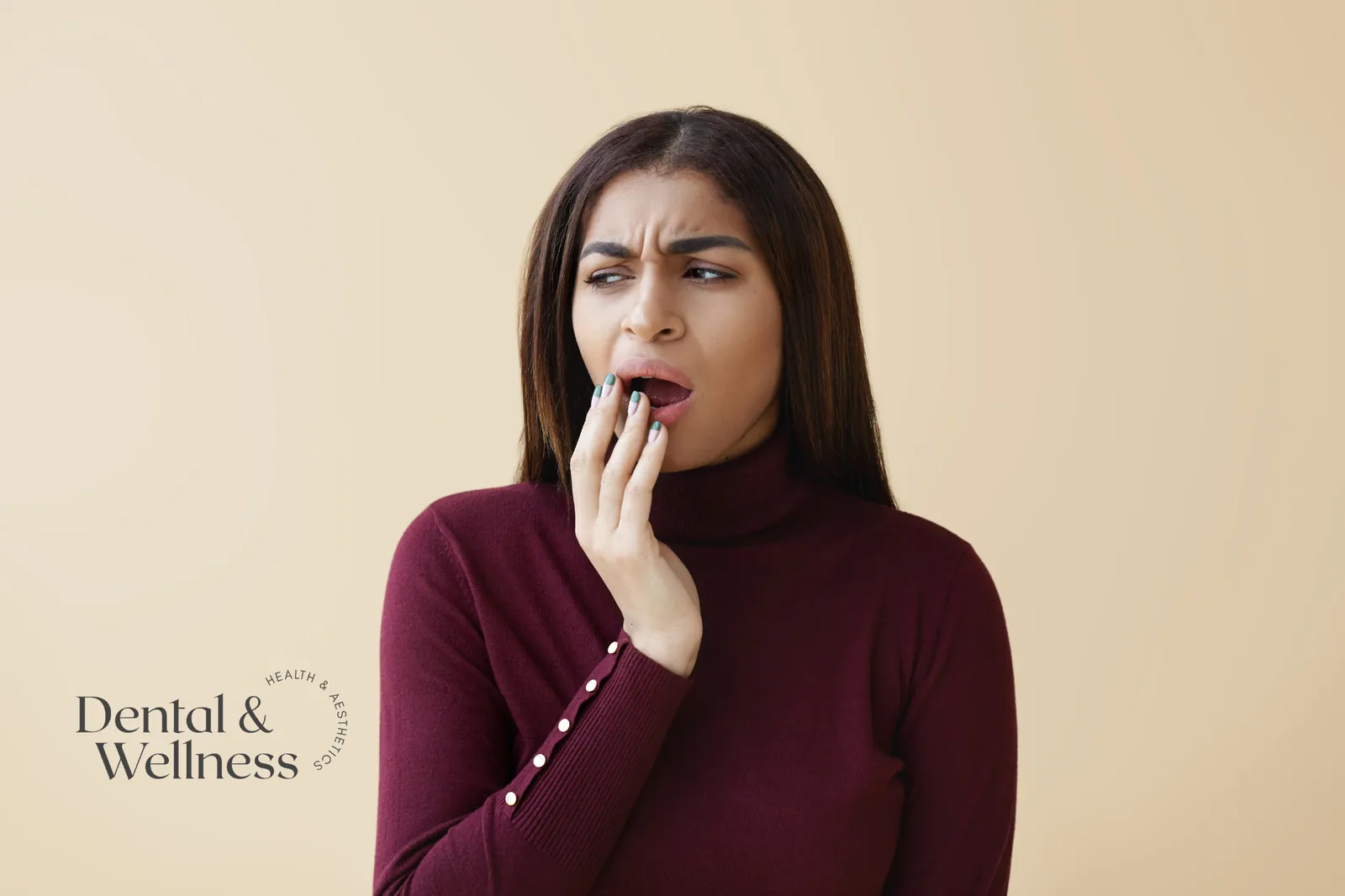 Mouth ulcer treatment: woman wincing and covering her mouth with her hand