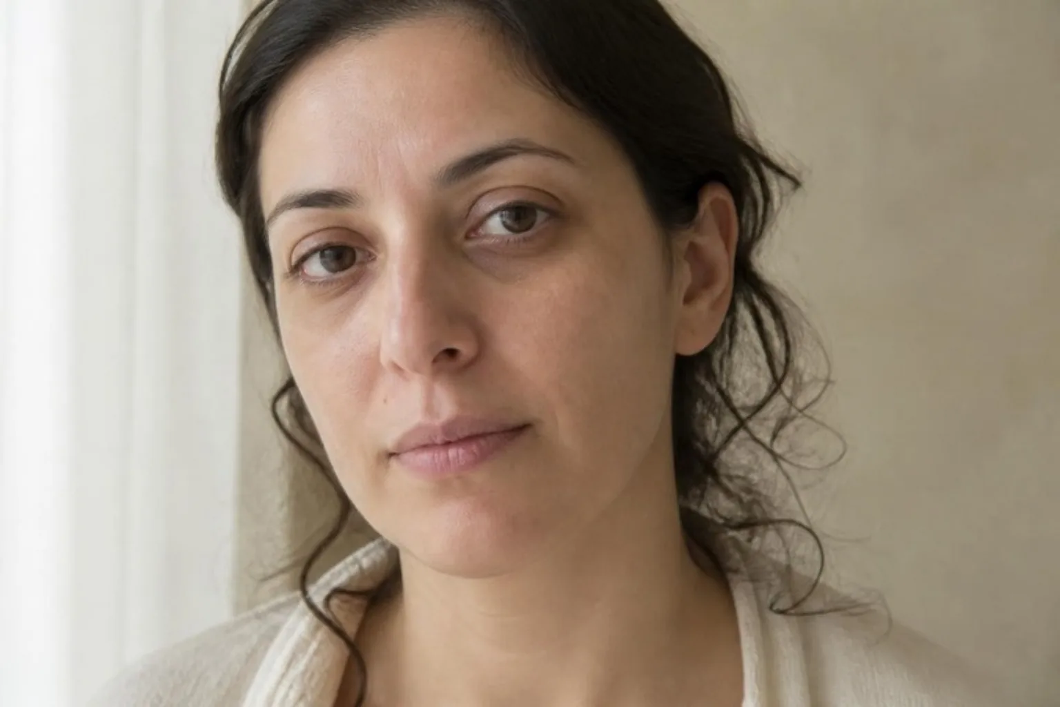 Dark circles treatment in Islington, London: woman with shadows under her eyes in soft natural light
