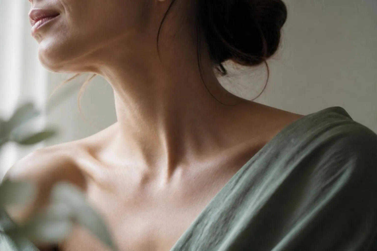 A woman's neck and collarbone area in soft daylight, natural skin