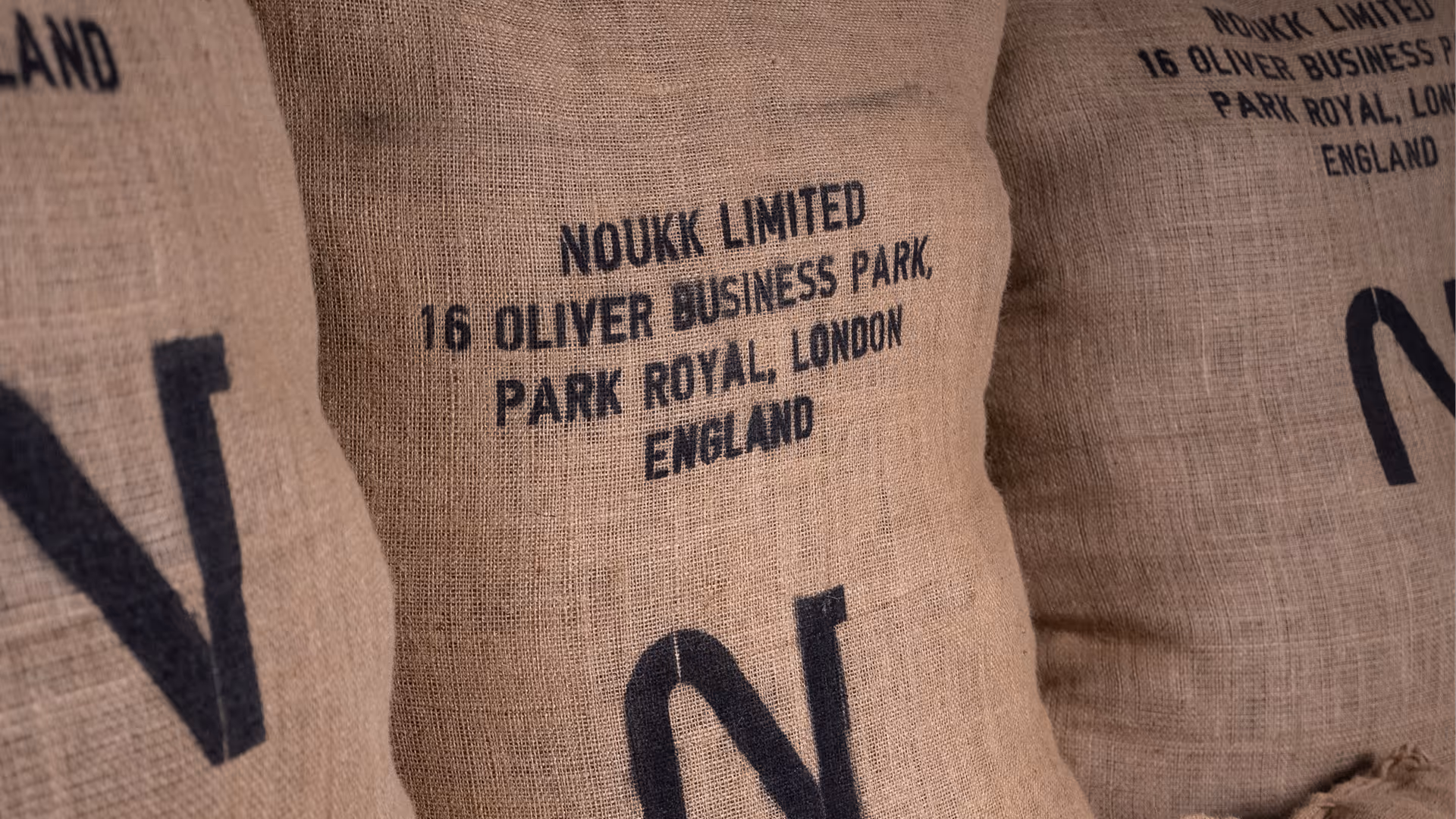 NOUKK Limited branded hessian sack stamped with London headquarters address at 16 Oliver Business Park, Park Royal