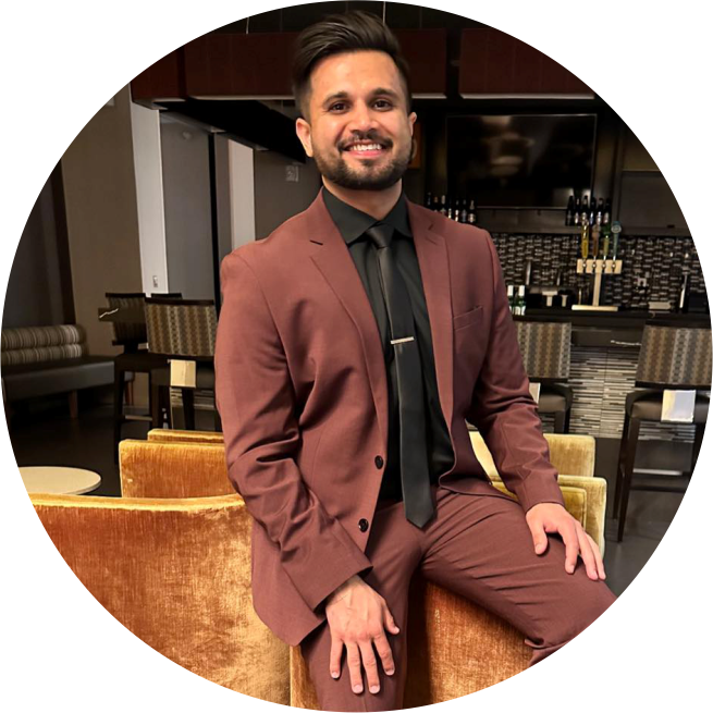 Silhouette of a woman wearing sunglasses against a bright orange background, her hair tied up in a messy bun.