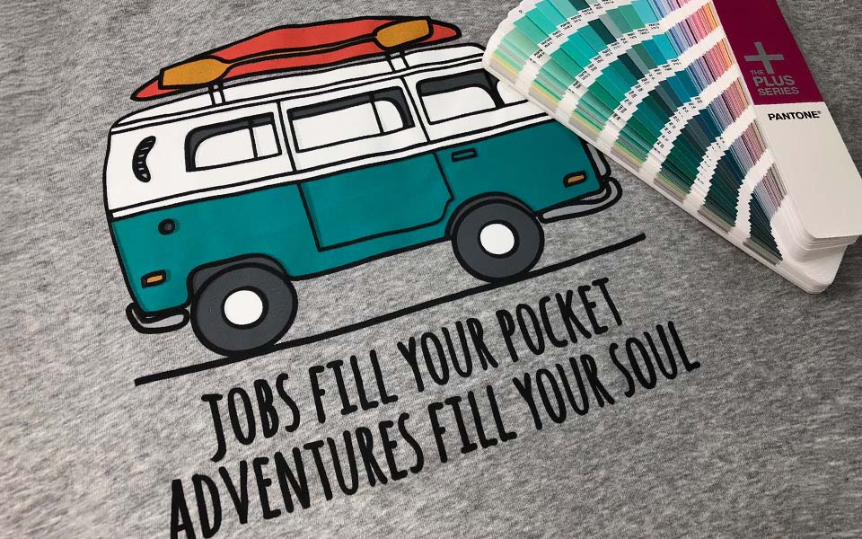 A close-up view of a screen printed result with a Pantone color chart next to it
