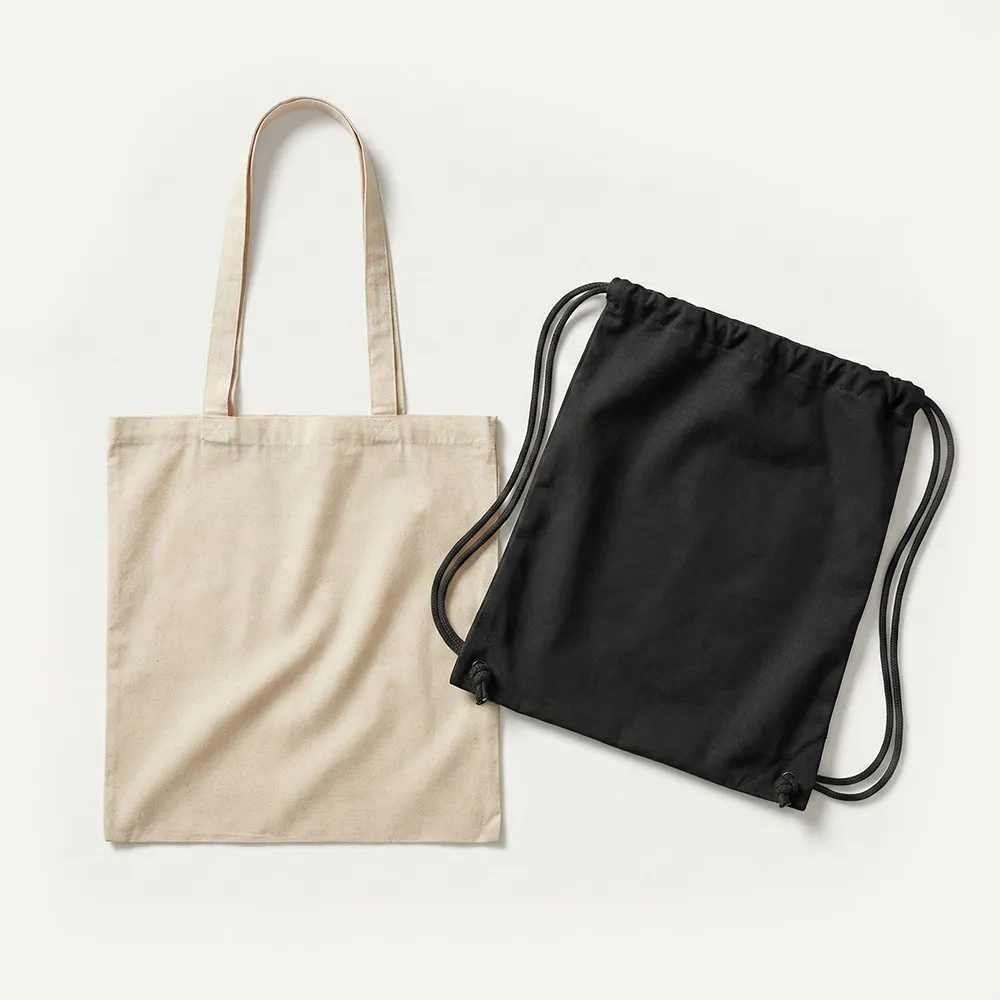 Schlichte beige Tragetasche mit Henkeln neben einem schwarzen Turnbeutel auf weißem Hintergrund.