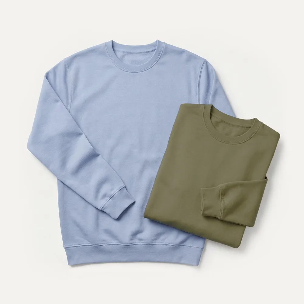 Ein hellblaues Sweatshirt mit Rundhalsausschnitt neben einem gefalteten olivgrünen Sweatshirt mit Rundhalsausschnitt auf weißem Hintergrund.