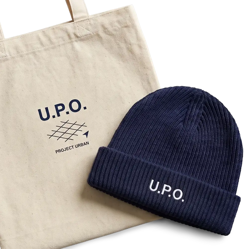Natürliche Stofftasche mit U.P.O. Logo und blauer Strickmütze mit U.P.O.-Schriftzug.