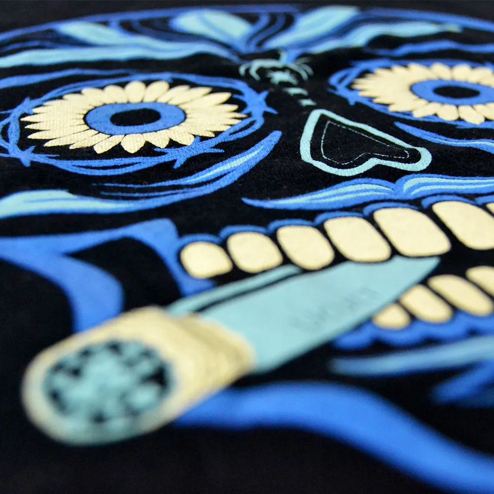 Nahaufnahme eines Siebdrucks: blaues Sugar-Skull-Motiv auf schwarzem Shirt