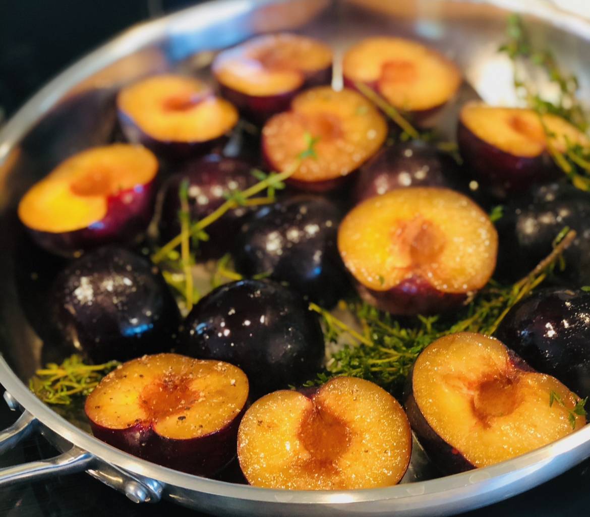 A professional cast-iron skillet featuring a vibrant seafood paella with seared scallops, fresh shellfish, succulent shrimp, and bright green peas.