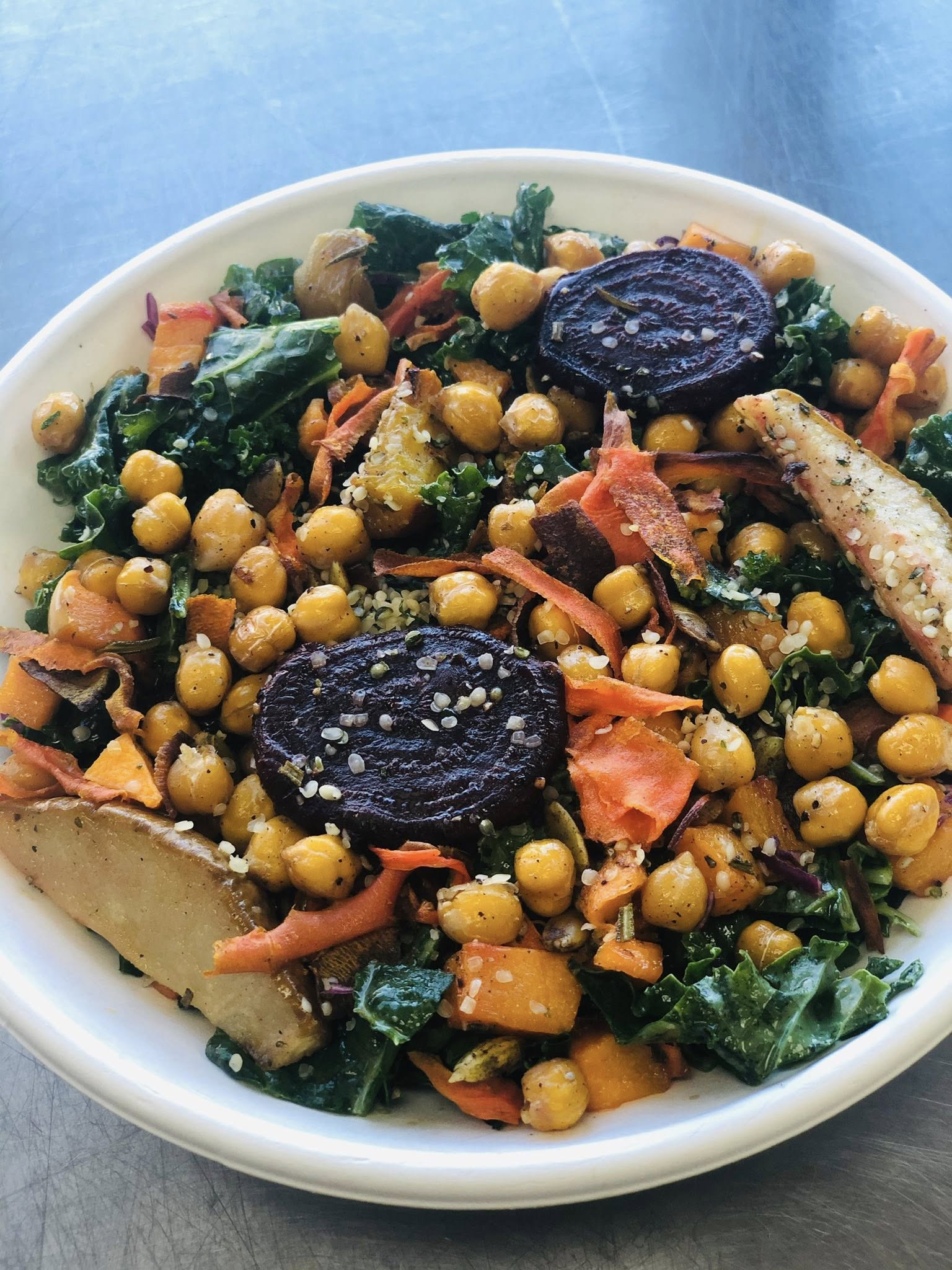 A professional catering platter featuring dozens of fresh Caprese skewers with vibrant cherry tomatoes, creamy mozzarella pearls, and fresh basil leaves.