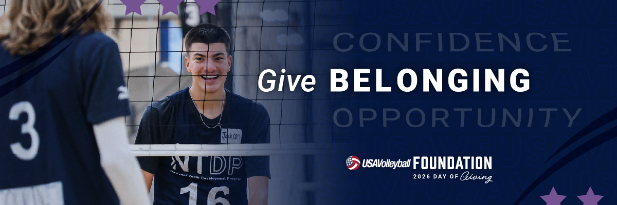 Male volleyball player at National Team Development Program smiling through a volleyball net. Banner says Give Belonging