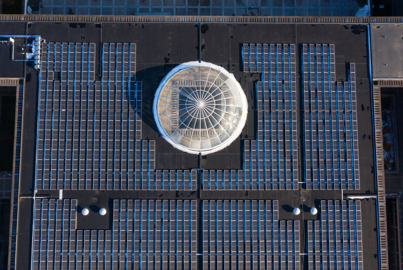An aerial view of a building with solar panels on it's roof