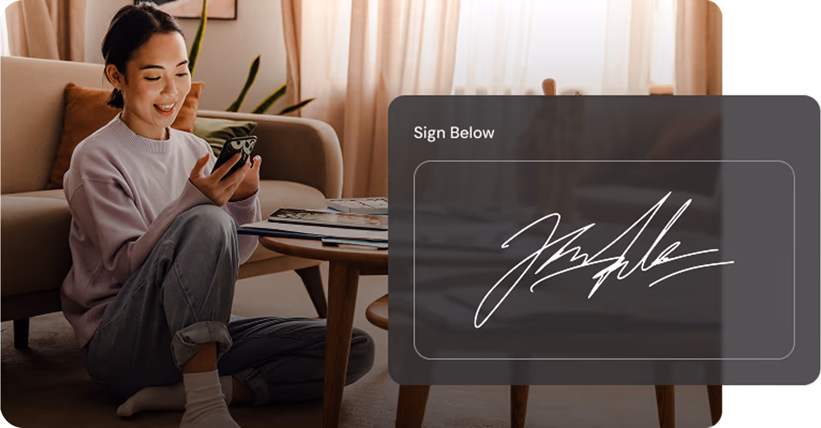 Woman sitting on floor using phone with digital signature box displayed nearby reading Sign Below.