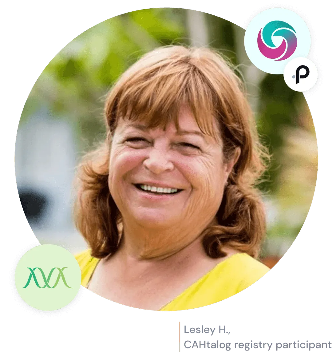 Smiling middle-aged woman with light brown hair wearing a yellow top outdoors.