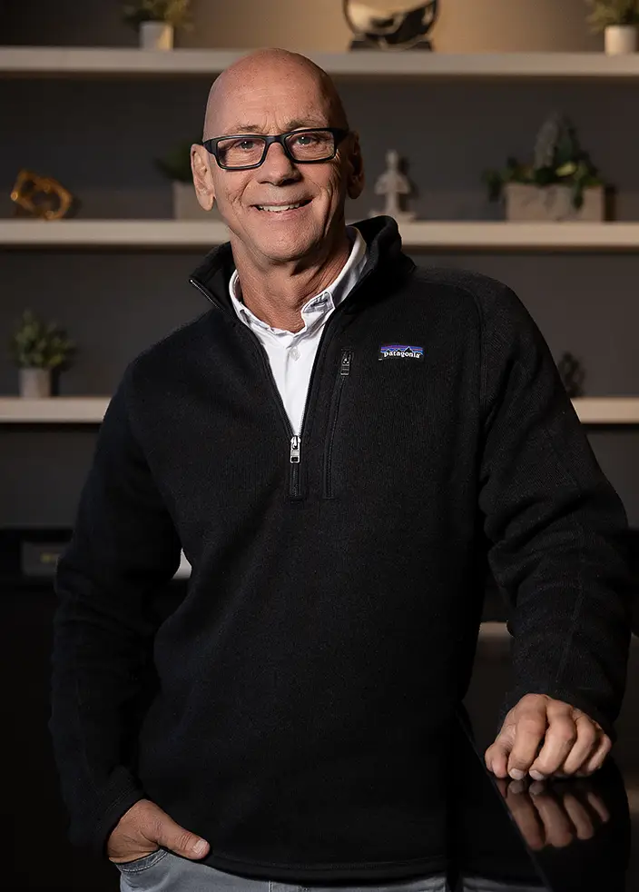 Dr. Gladden wearing glasses and a black Patagonia fleece smiling at the camera.