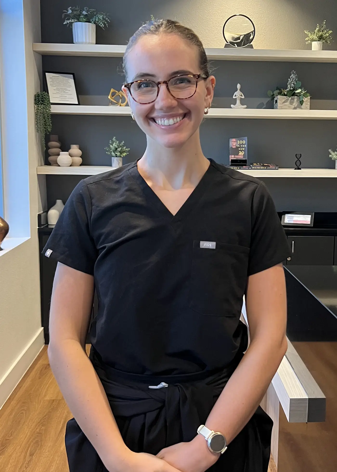 RN, BSN Molly, standing in the front lobby of Gladden Longevity in black scrubs