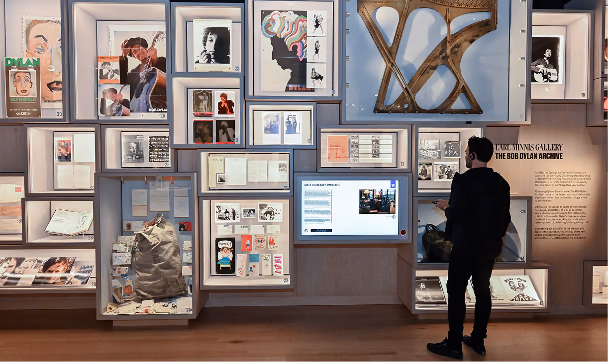 Man viewing exhibits and screen at the Earl Minnis Gallery, part of the Bob Dylan Archive museum.