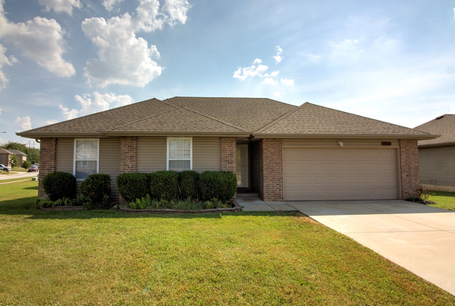 Brick ranch rental home with trimmed shrubs in Springfield, Missouri