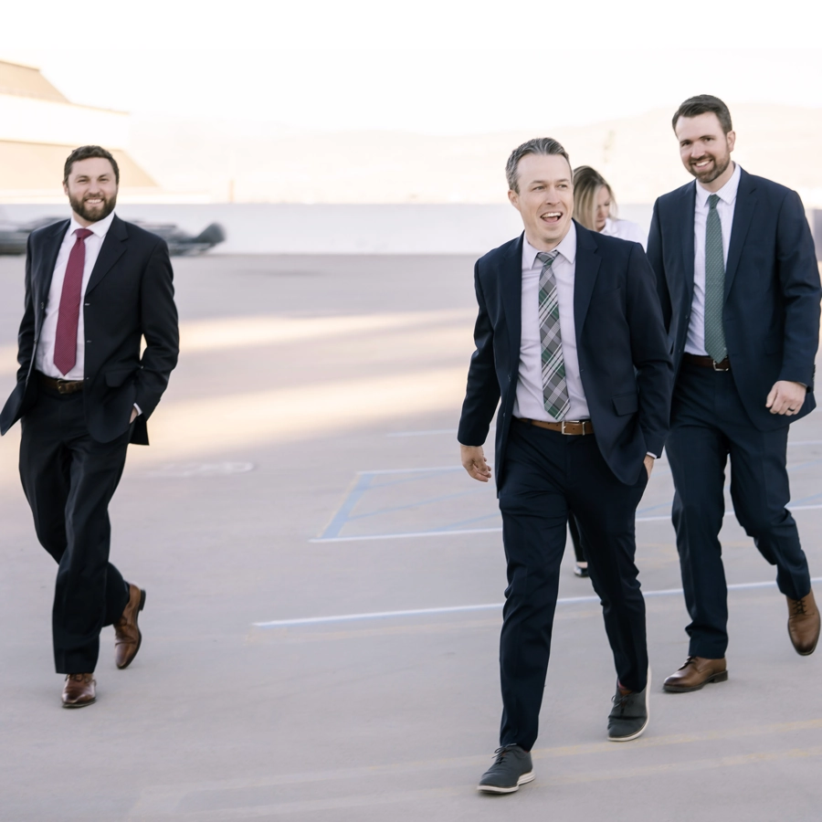 Four lawyers walking through parking lot with joyful attitudes