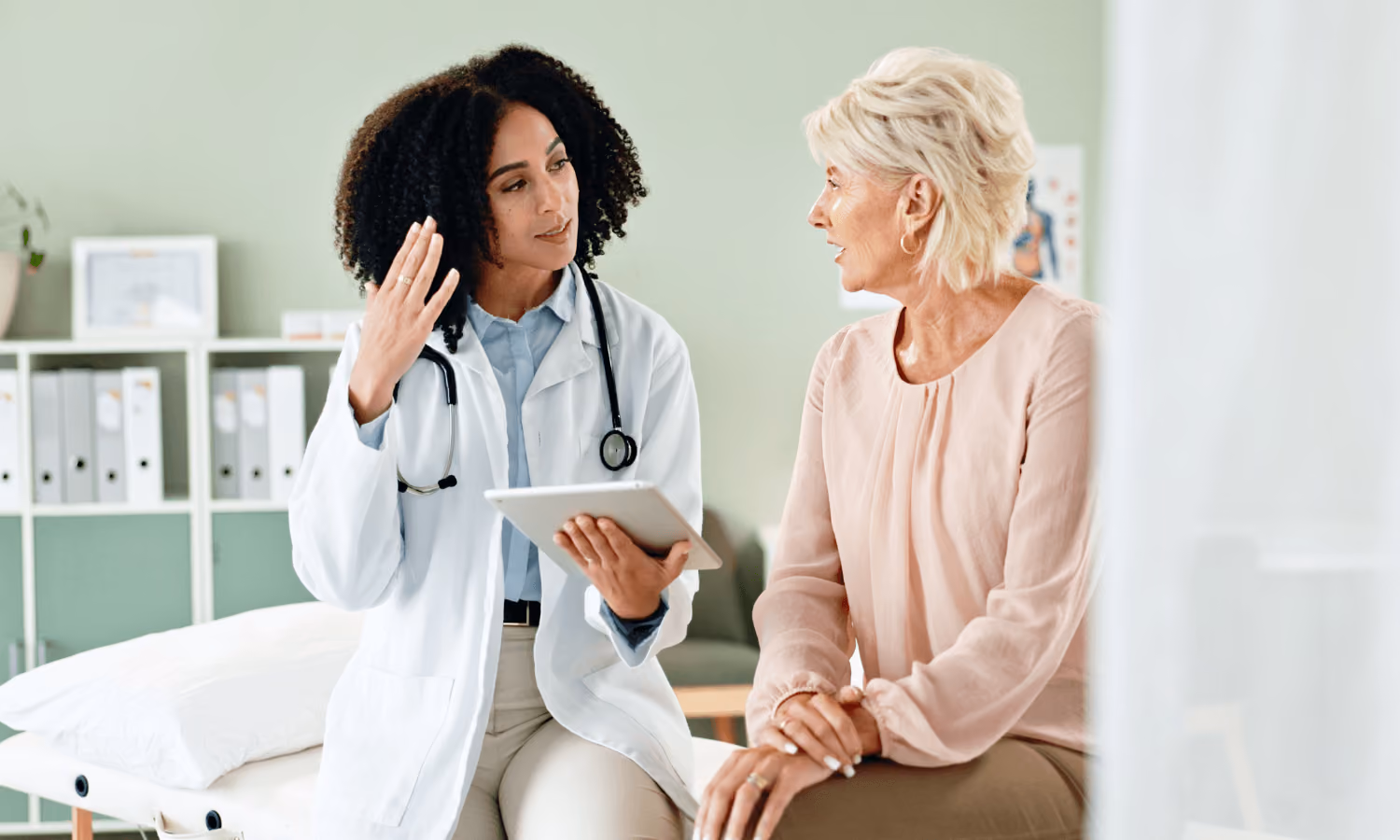 A patient meets with a doctor in a hospital. 