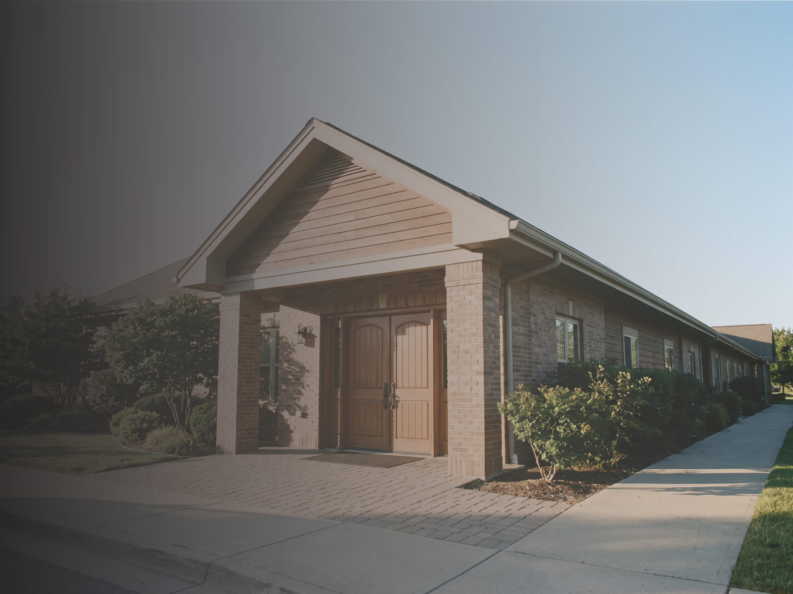 Single-story assisted living facility exterior in morning light, appraised for its market valuation