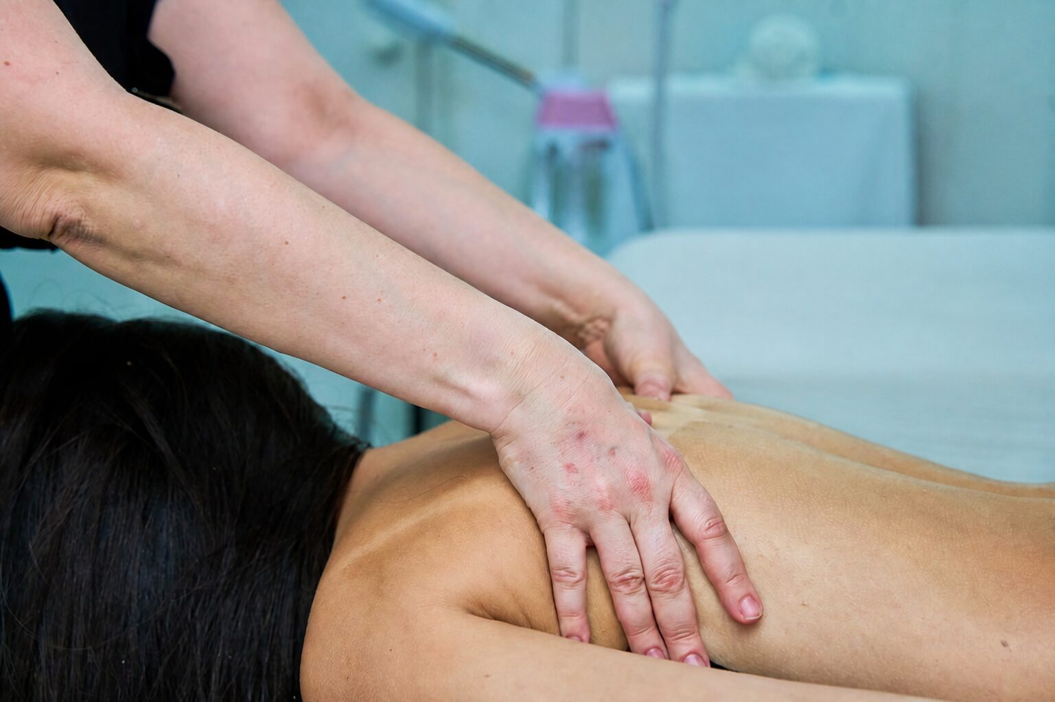 Therapist performing manual lymphatic drainage on the back and shoulders